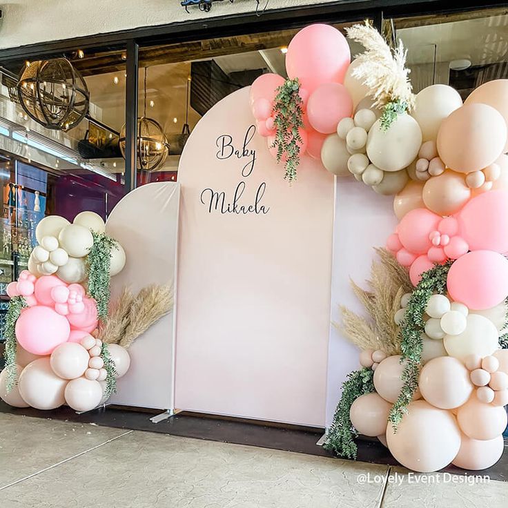 an entrance decorated with balloons and greenery for a baby shower or bridal party