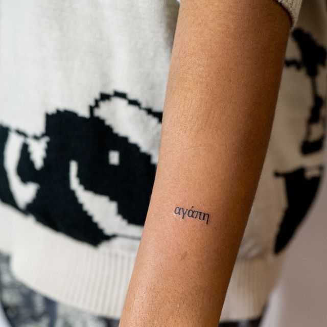 a woman's arm with a small tattoo on it that reads, ayem