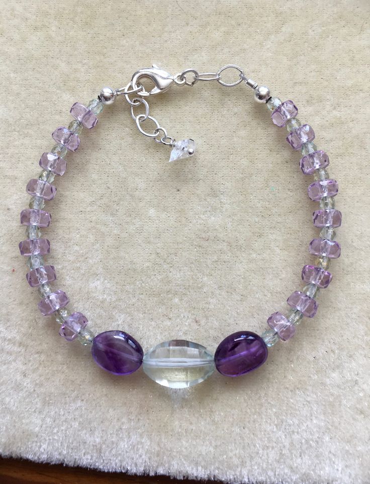 "This bracelet is one of a kind!  Beautiful Amethyst gems and a Prasiolite focal.  The gems are of the highest quality and strung on quality jewelry wire for strength and longevity.  The size is adjustable from 7\" to 7-1/2\"." Faceted Sterling Silver Gemstones, Sterling Silver Rondelle Gemstone Bracelets, Sterling Silver Amethyst Bracelet With Gemstone, Handmade Adjustable Amethyst Sterling Silver Bracelet, Adjustable Faceted Sterling Silver Gemstones, Faceted Amethyst Bracelets, Faceted Amethyst Round Bracelets, Sterling Silver Crystal Bracelet With Natural Stones, Amethyst Gemstone Crystal Bracelet