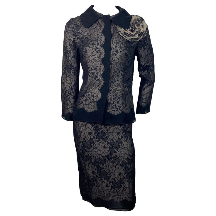 Dolce and Gabbana Black Silk and Gold Lace Skirt Suit - Size 40 This gorgeous skirt and jacket are made of 2 black silk chiffon layers with a gold lace fabric inserted in between creating an elegant combination. The jacket has a rounded 3.5” black satin collar, round neckline, 4 hidden snaps down the front closure area, bracelet sleeve and a removable large camilia brooch. Th skirt has a 1” grosgrain ribbon for a waistband with a hidden snap, 6” zipper and 7” kick pleat. The jacket is a size 40 and the skirt a size 38. The ensemble is in excellent condition and the measurements are: Jacket: Shoulder to Shoulder 15” Bust 35” Waist 32” Hips 36” Sleeve length 21.5” Length from center back 23” Skirt: Waist 25.5” Hips 35” Length 25” Gold Lace Fabric, Dolce And Gabbana Suits, Bracelet Sleeve, Skirt And Jacket, Satin Noir, Kick Pleat, Gold Lace, Dolce & Gabbana, Skirt Suit