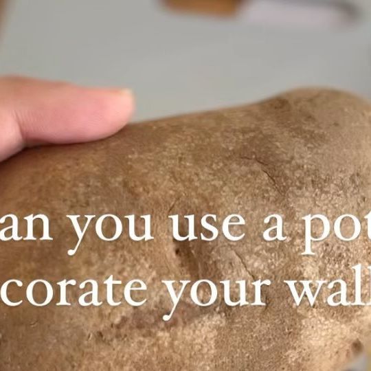 a person holding a loaf of bread with the words can you use a potato to decorate your wall?