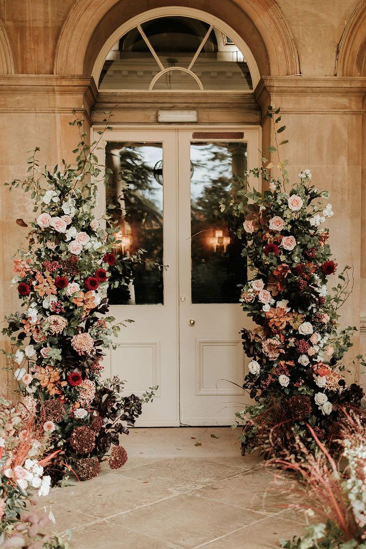 Pale pink and red autumnal wedding flower column decorations Fall Flower Arch Wedding, Rusty Red Wedding, Blush Autumn Wedding, Moody Wedding Ceremony Decor, Rust Floral Arrangement, Fall Floral Arch Wedding, Wedding Flower Tower, Wedding Flowers Autumn, Cedar Rose Wedding