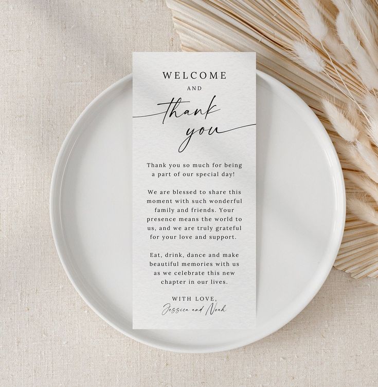 a white plate with a welcome and thank card on it next to some dried stalks