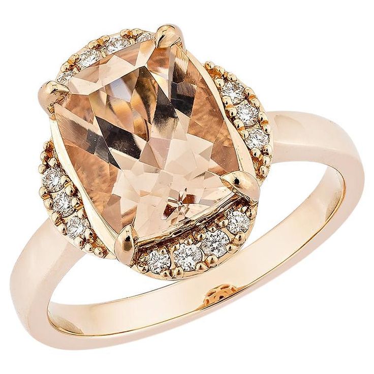 a ring with an orange and brown stone surrounded by white diamonds on the sides, set in 18k yellow gold