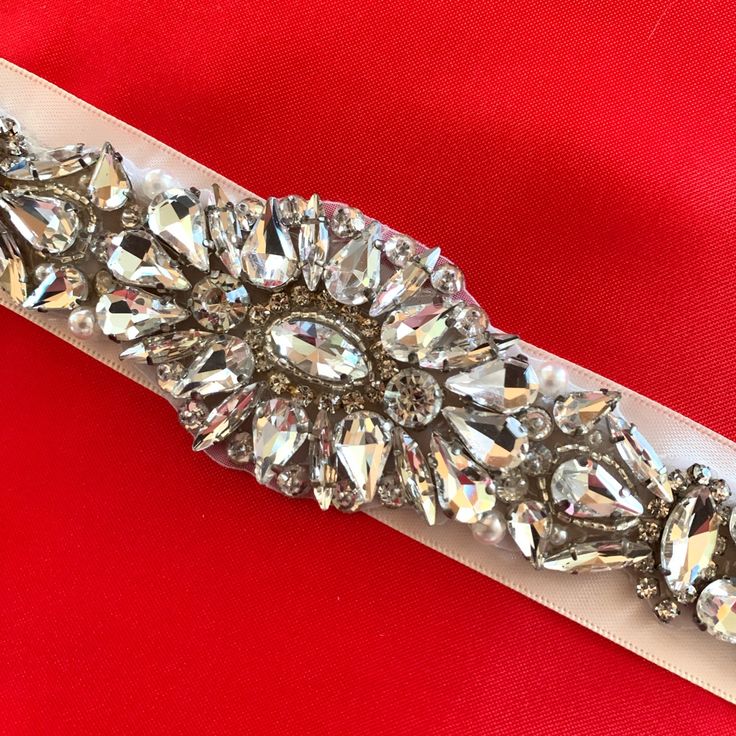 Beautiful Large Rhinestones Decorate This White Ribbon. Perfect Belt For Any Dress (Or Even Jeans) But Especially On A Wedding Dress. Perfect Condition. Never Used. Approx 65”Long. 1 1/4” Wide. The Rhinestones Stretch 9” Across The Center Of The Ribbon. Elegant Silver Bedazzled Sash, Elegant Bedazzled Silver Sash, Elegant Silver Bedazzled Sashes, Elegant Bedazzled Silver Sashes, Elegant Bedazzled Bridal Belt For Wedding, Glamorous Embellished Bridal Belt For Wedding, Elegant Bedazzled Wedding Sash, Glamorous Wedding Bridal Belt With Crystals, White Crystal Sashes For Formal Occasions