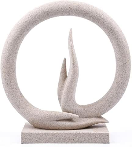 the sculpture is made out of concrete and has a circular base with an abstract shape