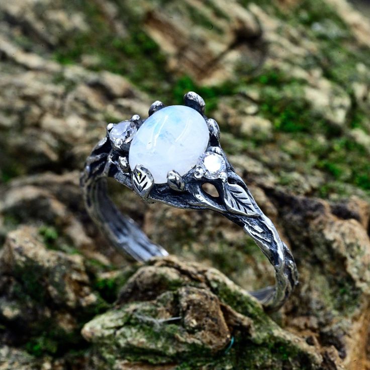 This sterling silver masterpiece is more than just a ring; it's a unique moon flower promise for the woman who appreciates vintage style and the beauty of nature. With its enchanting design and delicate moonstone, this ring captures the essence of a vintage forest wedding.  Characteristics: Metal - Recycled solid sterling silver  Stone - Moonstone Finish - Oxidized. View all silver sun and moon rings: https://www.etsy.com/shop/TinyShinyJewel?ref=seller-platform-mcnav&section_id=44309450 Care instructions: To care for the ring, avoid contact with water and chemicals such as perfumes and lotions. When the ring is not in use, store it in a dry, cool place to prevent tarnishing. Additional information:  ✦ All rings are made to order. An average turnaround time is 1-5 days. I will make every ef Vintage Forest Wedding, Forest Wedding Ring, Moon Rings, Perfumes And Lotions, Sun And Moon Rings, Vintage Forest, Branch Ring, Moonstone Engagement, Moonstone Engagement Ring