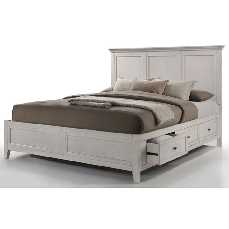 a white bed with drawers underneath it