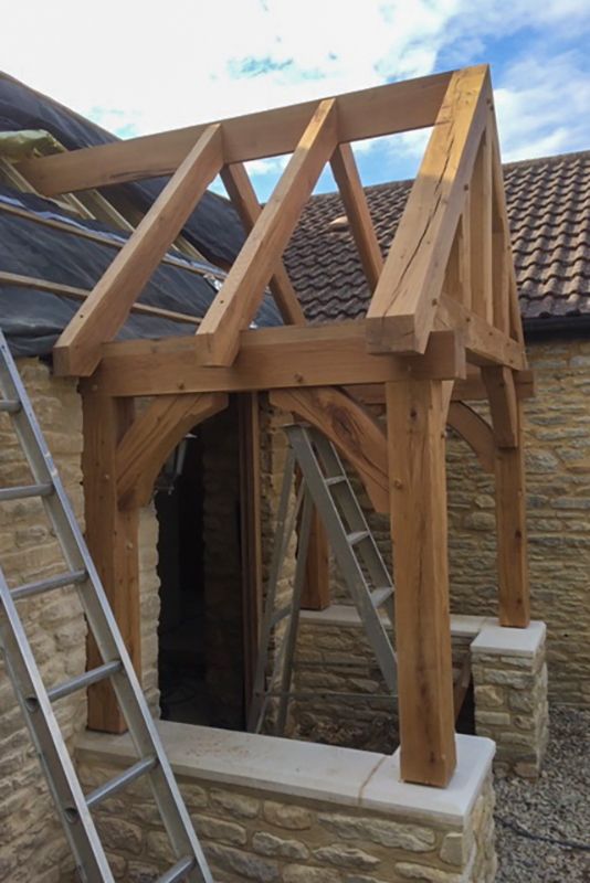 a house being built with wooden framing and roof trusses on the side of it