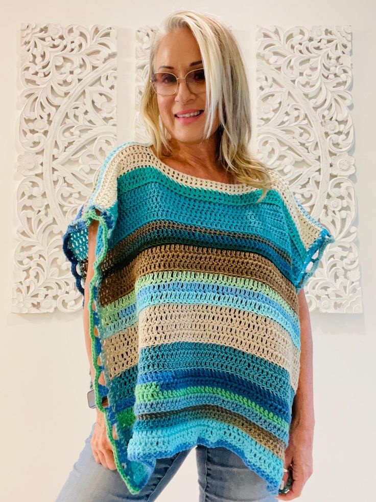 Welcome to LM Handmade Boutique! Perfect for layering in any season, more than just fashion--wearable art. Whether you're heading out for a casual day or dressing up for an evening event, this poncho adds a statement piece to your wardrobe. Limited Edition** Once it's gone, it's gone.   Get your one-of-a-kind poncho today and embrace your individuality with every wear! Step into a world where fashion meets craftsmanship. Each piece is lovingly handmade to create a truly one-of-a-kind piece.  No Green Bohemian Kaftan With Tassels, Bohemian Blue Top With Tassels, Bohemian Multicolor Poncho For Festival, Green Bohemian Tops With Tassels, Bohemian Green Tops With Tassels, Green Bohemian Poncho For Spring, Bohemian Green Poncho For Spring, Handmade Bohemian Blue Poncho, Handmade Blue Bohemian Poncho