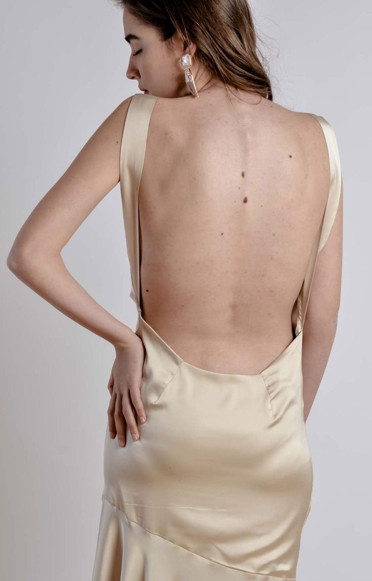 the back of a woman's dress with her hands on her hips and one hand on her hip