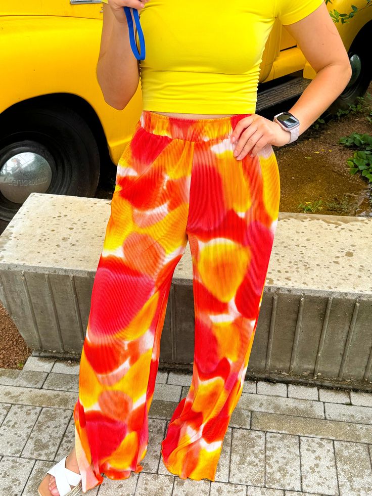 The cutest & comfiest pants you will EVER find!!! The shades of orange and yellow give major sunset vibes and can be styled with SO MANY COLORS!! We love pairing them with pinks, greens, and yellows but TRULY they go with every color!! Style them with a sweatshirt for a casual day or a cute blouse when meeting friends for brunch! True to size with a stretchy waistband 100% Polyester Soft and comfy pants! Style with yellows, pinks, greens, and purples Dress up with a blouse or keep it casual with Multicolor Vacation Pants With Elastic Waistband, Casual Colorful Wide Leg Bottoms, Multicolor Vacation Pants For Spring, Multicolor Pants For Spring Vacation, Multicolor Pants For Spring, Trendy Colorful Pants For Spring, Multicolor Spring Vacation Pants, Colorful Casual Summer Pants, Trendy Colorful Spring Pants