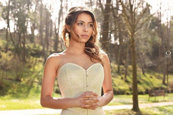 a beautiful woman in a white dress posing for the camera with trees in the background