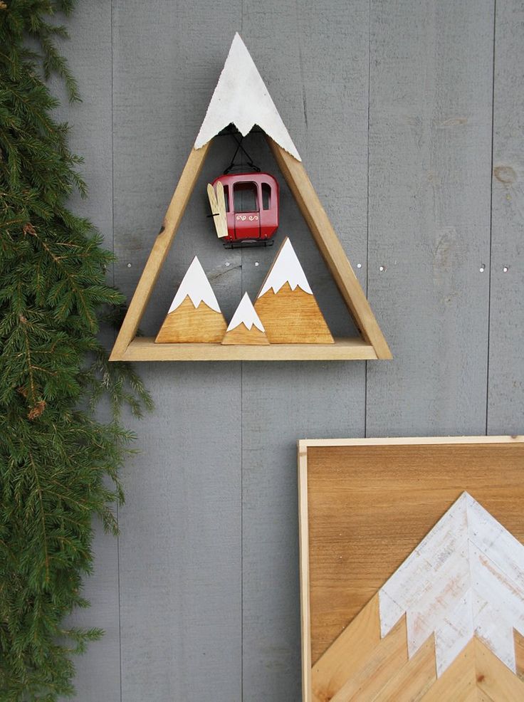 a wall mounted shelf with a car on top and mountains in the middle, next to a pine tree