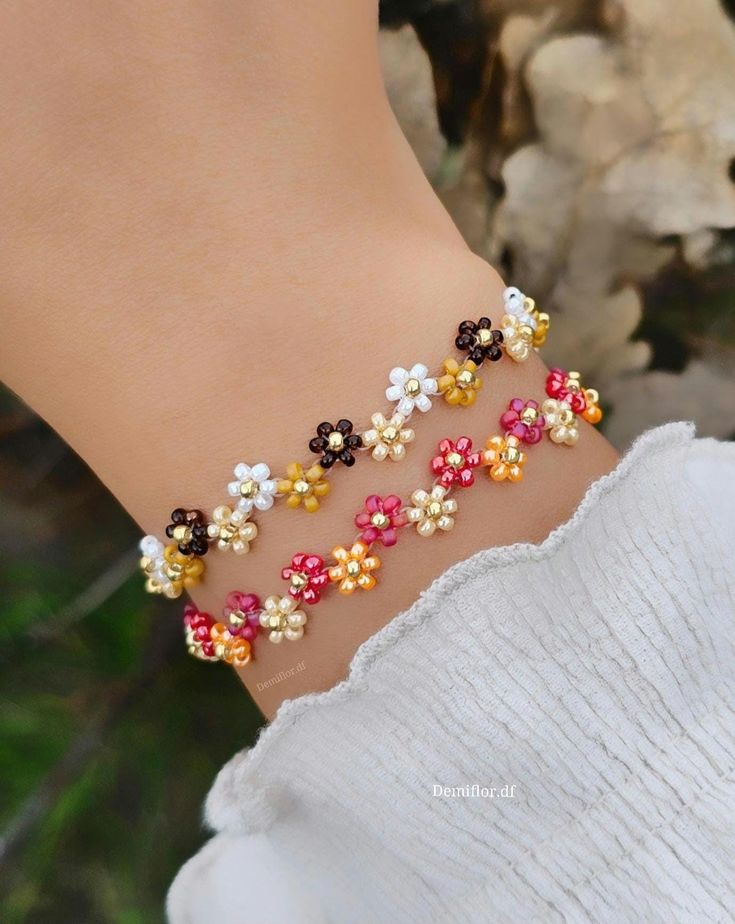 a close up of a person wearing a bracelet with flowers on it