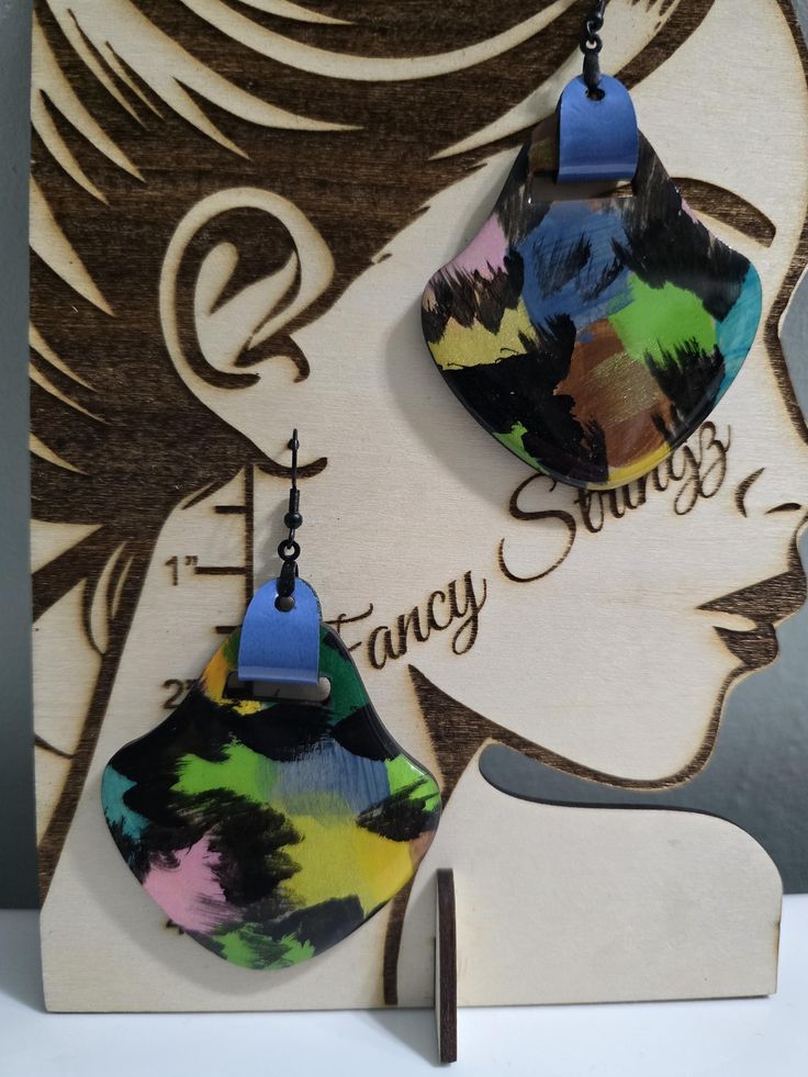 Discover the epitome of artisan craftsmanship with these exquisite hand-painted wood earrings from our exclusive collection. Each pair is meticulously crafted by skilled artisans who blend traditional techniques with contemporary design, ensuring every piece is a unique work of art. The natural grain of the wood provides a stunning backdrop for the intricate hand-painted patterns, creating a harmonious balance of texture and color. Lightweight and comfortable to wear, these earrings are not just Multicolor Hand Painted Earrings, Hand Painted Multicolor Modern Earrings, Modern Hand Painted Multicolor Jewelry, Artistic Hand Painted Earrings, Multicolor Hand Painted Drop Earrings, Artistic Multicolor Earrings, Artistic Multicolor Earrings With Colorful Design, Modern Multicolor Earrings With Bold Design, Modern Hand Painted Drop Earrings