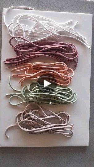 several different colored cords are laid out on a white board and placed in a rectangle