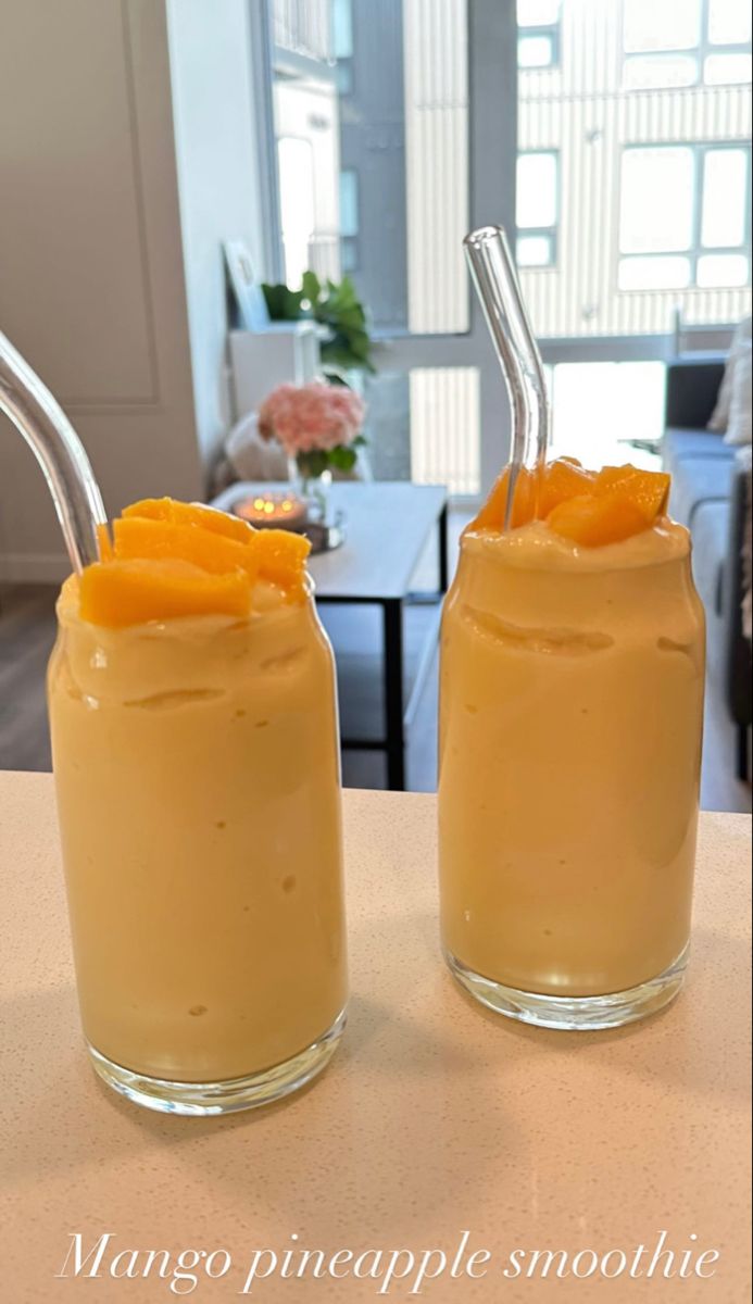 two glasses filled with orange juice on top of a table