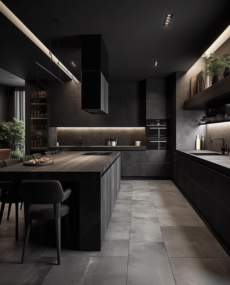 a large kitchen with black cabinets and counter tops, along with a dining room table