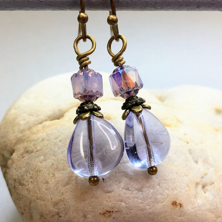 Enchanting lavender Czech glass teardrop earrings for an understated elegant look. Small iridescent beads top off lavender teardrops, adding just the right amount of sparkle. These cottagecore earrings make a stunning addition to any jewelry collection. Lavender is a versatile color, trending now. Beautiful with purple, green, pink, yellow, and more colors. Free gift packaging included. Earrings are carded and in an organza bag. Hypoallergenic ear wires (nickel and lead free). Select ear wire st Elegant Lavender Beaded Drop Earrings, Elegant Lavender Beaded Earrings, Hypoallergenic Purple Dangle Teardrop Earrings, Purple Teardrop Pearl Drop Earrings, Elegant Lavender Beaded Earrings With Dangling Beads, Purple Teardrop Earrings With Dangling Beads, Elegant Czech Glass Teardrop Earrings, Lavender Teardrop Earrings With Ear Wire, Czech Glass Teardrop Earrings With Ear Wire