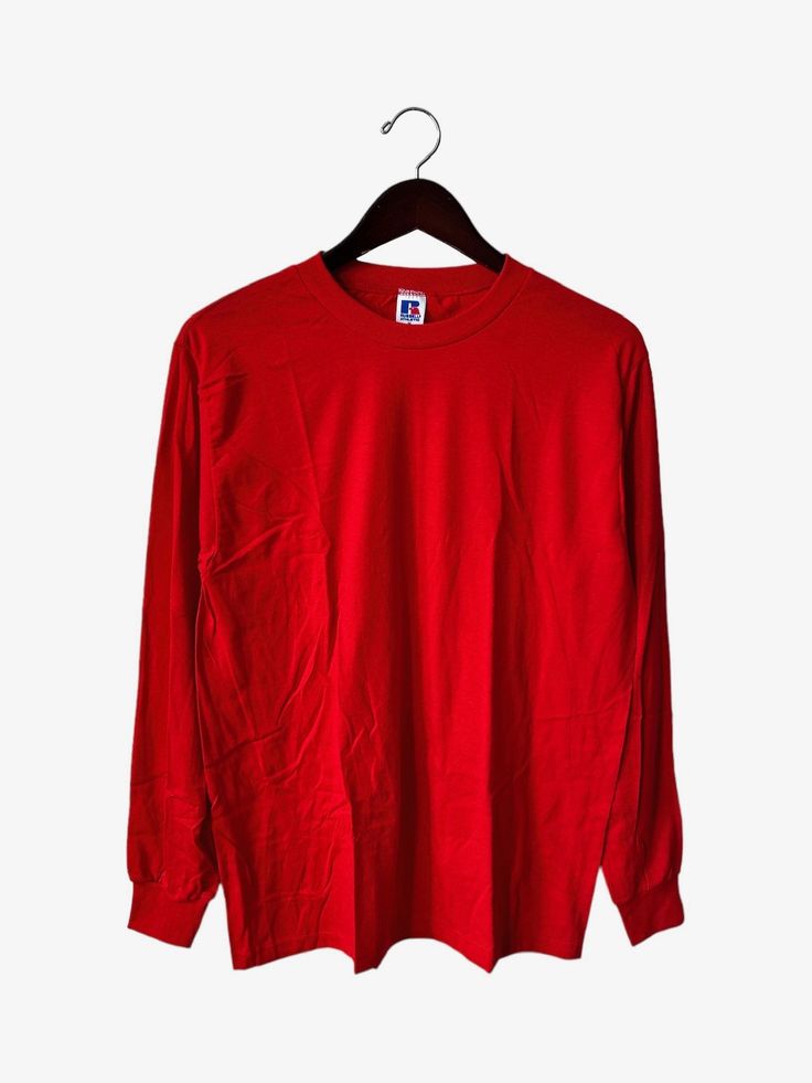 "early 90s russell athletic long sleeve shirt. deadstock. NWOT. scarlet red. 26.5\" long. 19\" across. 25.5\" arms. in excellent, unworn condition. made in USA. russell athletic founded in 1902. for the long run. legit. legitvintage.etsy.com legitvintage on instagram" Red T-shirt For Fall Streetwear, Oversized Red Long Sleeve Shirt, Red Fitted Long Sleeve T-shirt, Winter Streetwear Solid Color T-shirt, Pre-shrunk Long Sleeve Relaxed Fit T-shirt, Solid Color T-shirt For Fall Streetwear, Red Oversized Long Sleeve Shirt, Red Long Sleeve Winter Shirt, Red Long Sleeve Sweatshirt