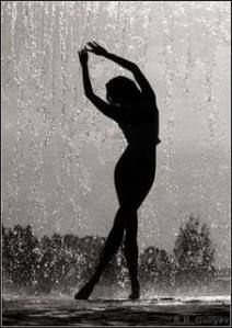 a woman standing in the water with her arms outstretched