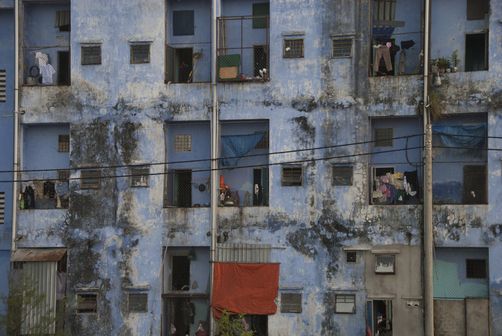 an old building with many windows and people on the balconies looking out at the street