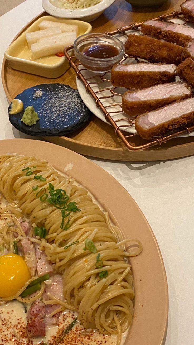 two plates filled with pasta, meat and eggs