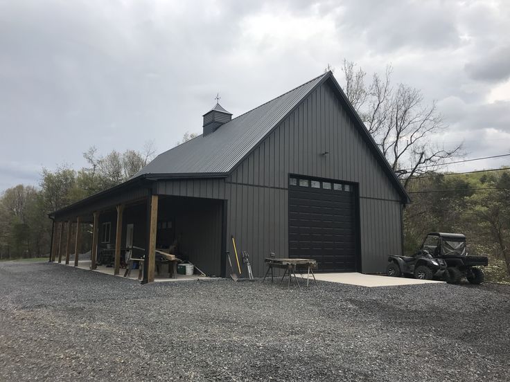 a black barn with an atv parked in front of it