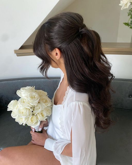 a woman sitting on top of a couch holding a bouquet of flowers in her hand