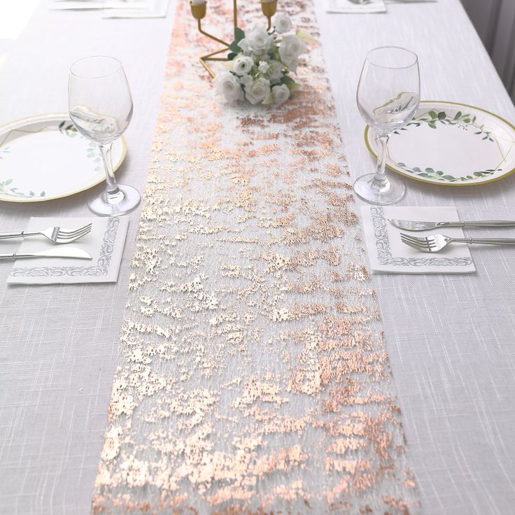 the table is set with white and gold place settings