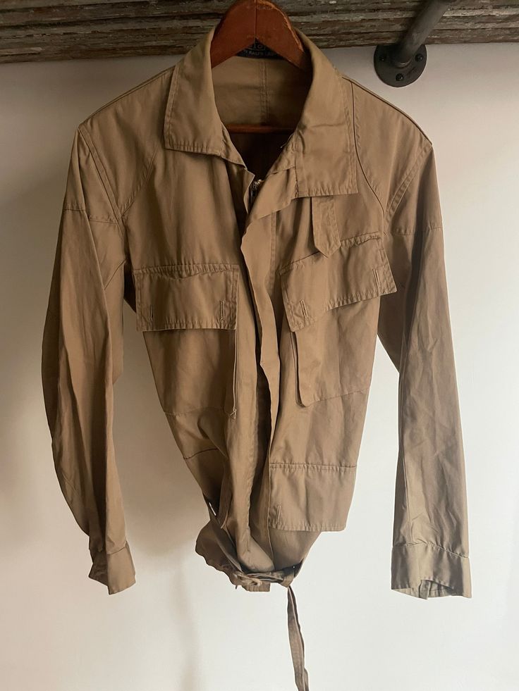 "Vintage early 80's Polo Ralph Lauren windbreaker moto explorers jacket size small. Four front flap button pockets. Waist tie. Chin strap. Small spot on back shoulder. 21\" armpit to armpit. 30\" long. 31\" sleeve length." Military Style Outerwear With Cargo Pockets For Adventure, Military Outerwear With Cargo Pockets For Adventure, Adventure Long Sleeve Utility Jacket With Pockets, Adventure Utility Jacket With Pockets, Adventure Long Sleeve Outerwear With Pockets, Long Sleeve Adventure Outerwear With Pockets, Long Sleeve Outerwear With Pockets For Adventure, Collared Utility Jacket For Outdoor, Utility Long Sleeve Windbreaker For Hunting