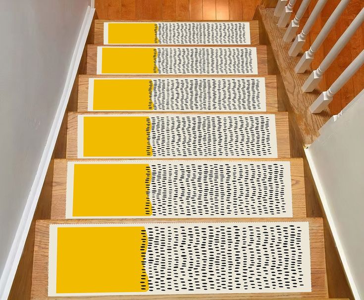 the stairs are painted yellow and white with black polka dots on each one side, along with matching rugs