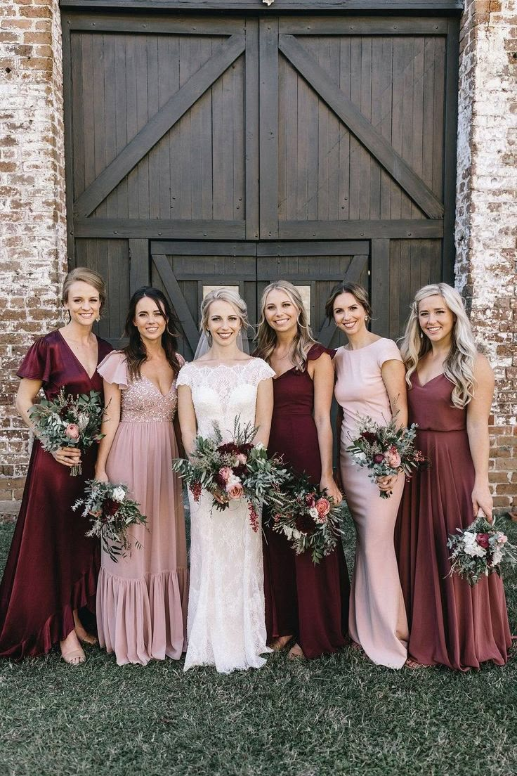 a group of women standing next to each other in front of a wooden barn door