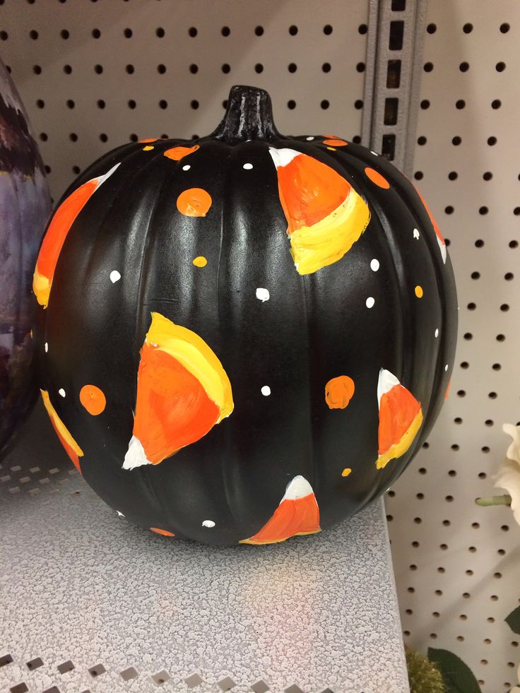 a painted pumpkin sitting on top of a shelf