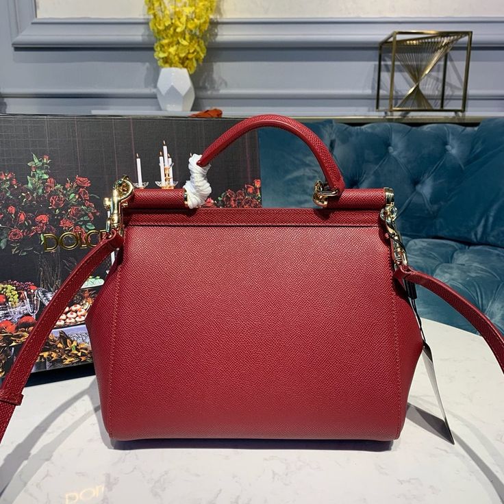 SHOP MORE LUXURY PRODUCTS HERE Description Dolce and Gabbana Small Sicily Bag In Dauphine Red For Women 7.5in/19cm DG Size: 13 x 19 x 6 cm / 5.1 x 7.5 x 2.4 inches (Length x Width x Height) Front flap with hidden magnetic fasteningBranded tag featuring two metal plating finishesTop handle and adjustable, detachable strap in DauphinePrinted fabric lining and flat pocketItem comes with a branded dust bag Includes box, dust bag.This product is of the premium quality. Red Luxury Shoulder Bag For Daily Use, Luxury Red Bags For Daily Use, High-end Red Shoulder Bag, High-end Red Crossbody Bag, High-end Red Shopping Bag, Luxury Red Shoulder Bag With Removable Pouch, High-end Red Bag With Removable Pouch, High-end Red Bag With Detachable Handle, Luxury Red Top Handle Bag