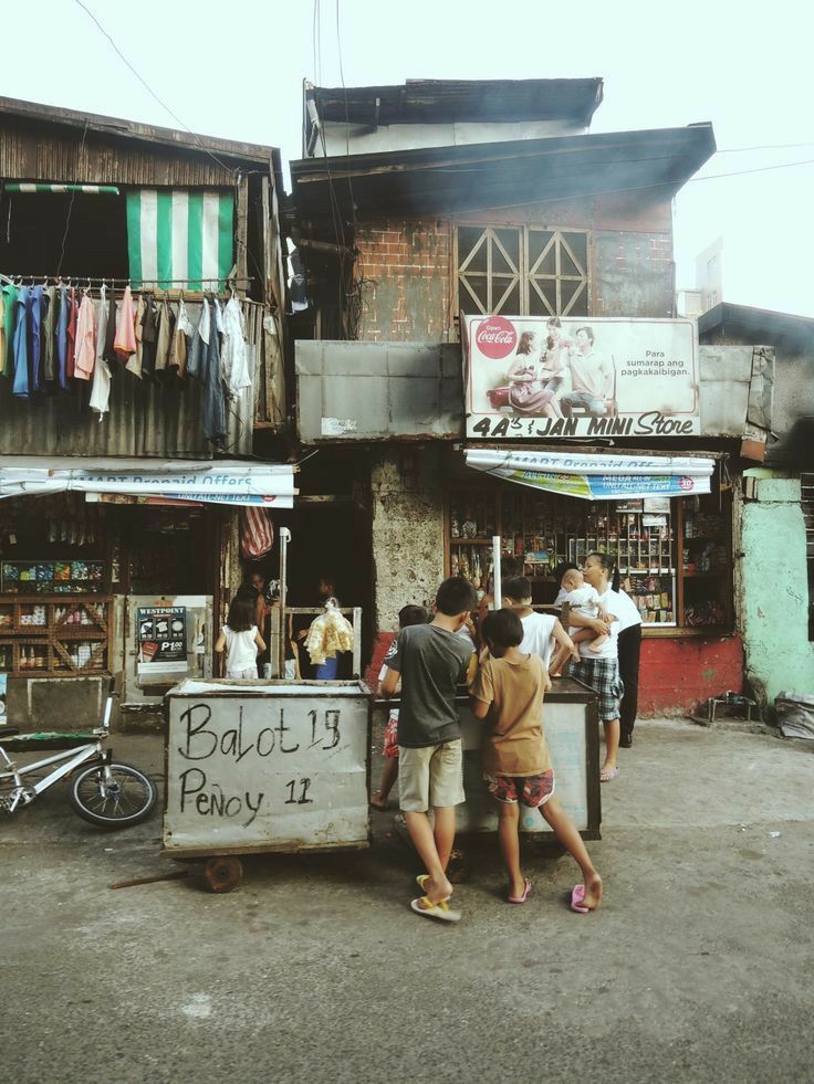 some people are standing in front of a small store with a sign that says back 19 pay it