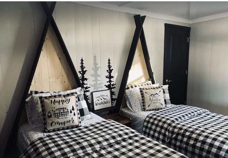 two twin beds are decorated with black and white plaid comforters, pillows and pillow cases