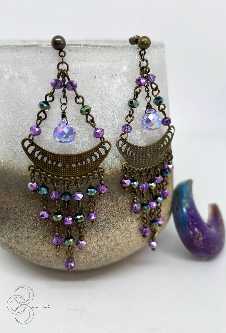 They are earrings with a special and delicate design. They are made with die-cut charms with the phases of the moon, some lilac glass drops and glass beads in purple and green tones. If you have any questions, don't hesitate to write to me. You can see more items from my store here: https://www.etsy.com/es/shop/TresLunasTienda Thank you very much for your visit! :) Purple Metal Chandelier Earrings As Gift, Purple Metal Chandelier Earrings For Gifts, Purple Drop Crystal Earrings, Purple Dangle Chandelier Earrings, Purple Metal Chandelier Dangle Earrings, Purple Crystal Drop Earrings, Purple Dangle Crystal Earrings, Hypoallergenic Purple Bohemian Earrings, Purple Metal Dangle Chandelier Earrings