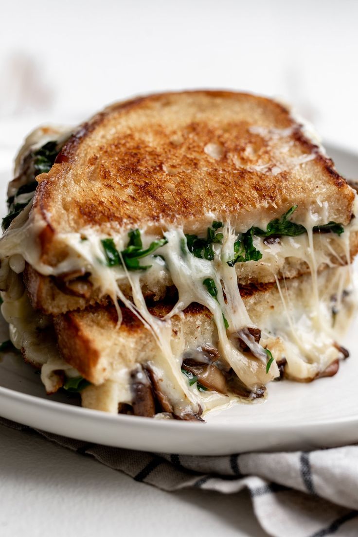 a grilled cheese and mushroom sandwich on a white plate