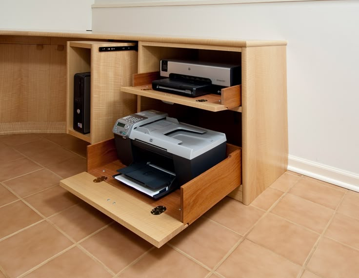 an open cabinet with printer and scanners in it on the floor next to a wall