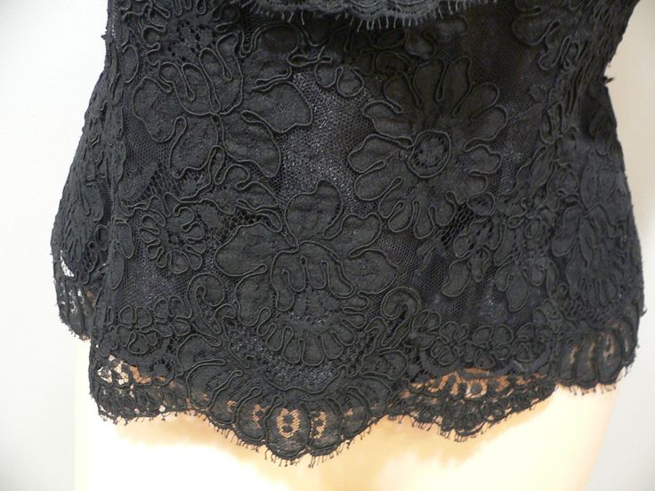 Gorgeous vintage black alencon lace blouse for evening wear. It is labeled Watters and Watters with the fabric contents and care pictured. My guess is 60's - 80's . This lace is fabulous with heavy cording around the flowers in an all over floral pattern. The top has slight off the shoulder wide straps or sleeves which fall to a v shape on both front and back. It is fitted along the waist. All edges have the eyelash of the lace showing on the scalloped edging. Inside is lined in both a netting a Elegant Black Top With Scalloped Lace, Elegant Black Tops With Scalloped Lace, Elegant Black Scalloped Lace Top, Fitted Scalloped Lace Evening Blouse, Fitted Evening Blouse With Scalloped Lace, Black Scalloped Lace Top For Night Out, Black Lace Top With Lace Patchwork For Night Out, Elegant Black Lace Top, Formal Scalloped Lace Top