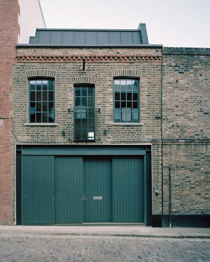 an old brick building with two garage doors