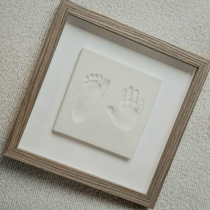 a white frame with two hand and foot prints in it