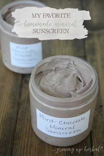 two jars of homemade mineral sunscreen on a wooden table with the label above them