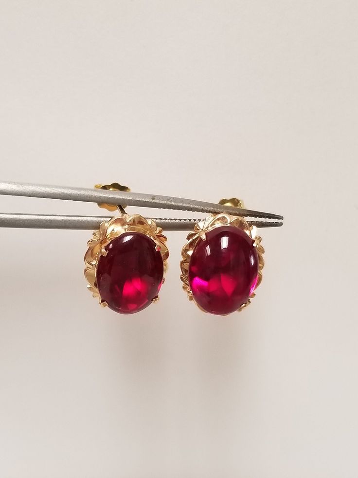 "Thanks for shopping our vintage estate store. We tend to sell well below wholesale and truly hope you enjoy all of our items. Many of the items are one of a kind, so please enjoy scrolling through the pictures and hopefully something will catch your eye. Brown spots are from camera or reflections. Nice estate 18k yellow gold natural 6ct ruby or spinel stud earrings. Assuming these are spinel, testing ruby, but a lot of these types of gems will test natural and may even be created. Size: 1/2\" by 3/8\" Ruby: 11mm by 8mm Weight: 3.83 grams Gems: 3ct each ruby Marked 18k and these are stunning. These are antique earrings." Luxury Oval Ruby Earrings, Luxury Oval Earrings For Formal Occasions, Elegant Oval Hallmarked Earrings, Luxury Yellow Gold Oval Clip-on Earrings, Classic Oval Clip-on Earrings With Polished Finish, Luxury Oval Cabochon Earrings For Anniversary, Luxury Oval Yellow Gold Clip-on Earrings, Formal Yellow Gold Gemstone Clip-on Earrings, Classic Round Cabochon Earrings