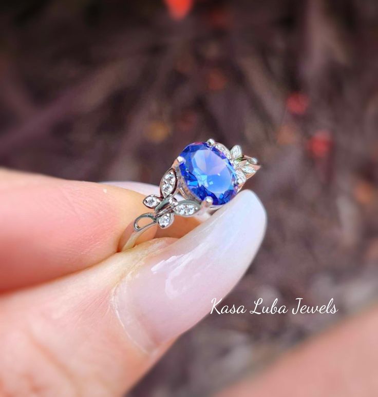 Tanzanite butterfly and Clear Cubic Zirconia SOLID sterling stamped 925 silver Tarnish free sizes 4-10 Top of ring height: 8mm Top of ring width: 6mm Band width: 1.7mm Shank width: 1.7mm Stone material: tanzanite & clear cubic zirconia Center stone size: 8mm x 6mm Stone shape: oval & round Center stone carat weight: 1.2 ct. Total number of CZ stones: 17 Stone setting: prong setting Metal: 925 sterling silver Plating: rhodium plated Finish: high polish simply stunning. High Polished, solid 925 sterling silver. Rhodium plated to prevent tarnishing. TARNISH FREE Rhodium plated to avoid tarnishing Nothing but the best from my custom jewelry store. Email me if you have any questions. Elegant Round Butterfly Ring Stamped 925, Elegant Butterfly Wedding Ring Stamped 925, Elegant Wedding Butterfly Ring Stamped 925, Elegant Blue Sterling Silver Butterfly Ring, Elegant Butterfly Shape Gemstone Rings, Silver Tanzanite Solitaire Jewelry, Butterfly Gemstone Ring For Gift, Ring Butterfly, Vero Beach Fl