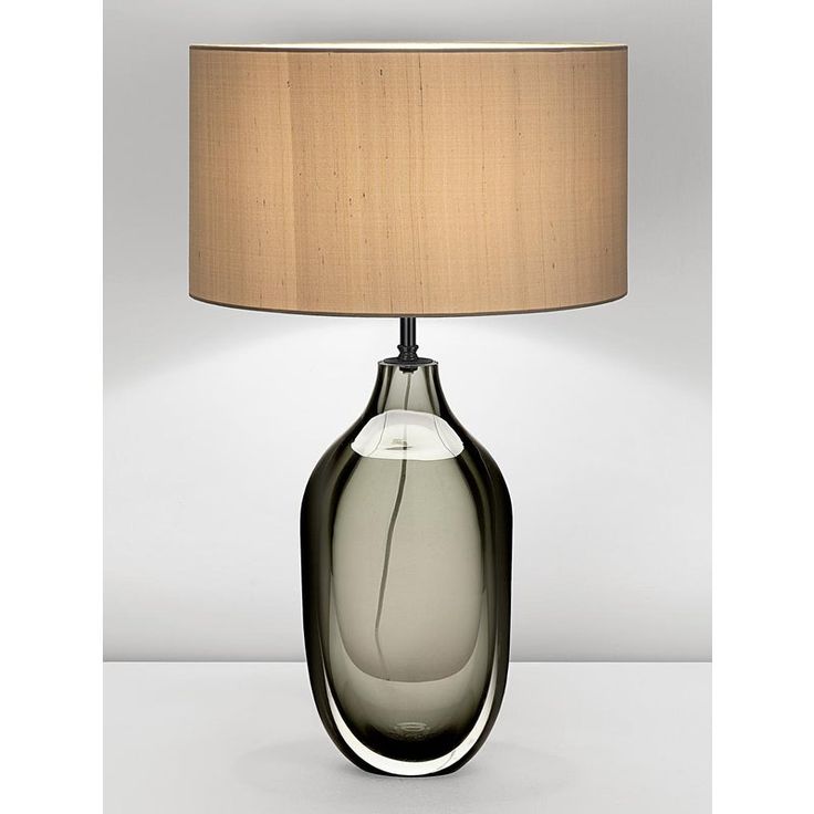 a table lamp with a shade on it and a white light in the corner next to it