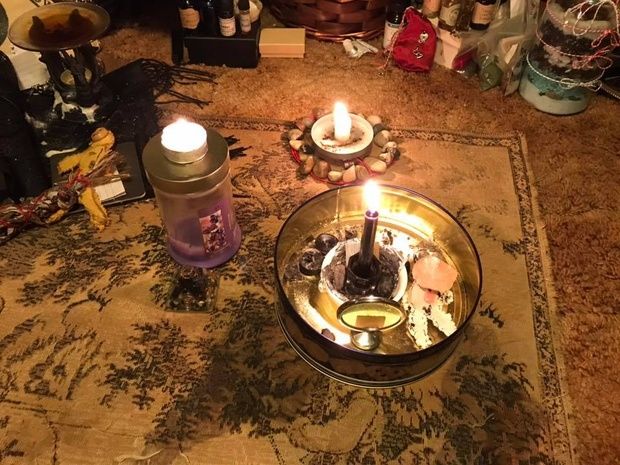 a lit candle sitting on top of a table next to other items in a room