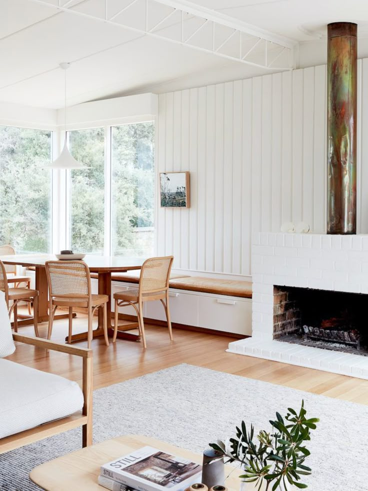 a living room filled with furniture and a fire place in front of a large window